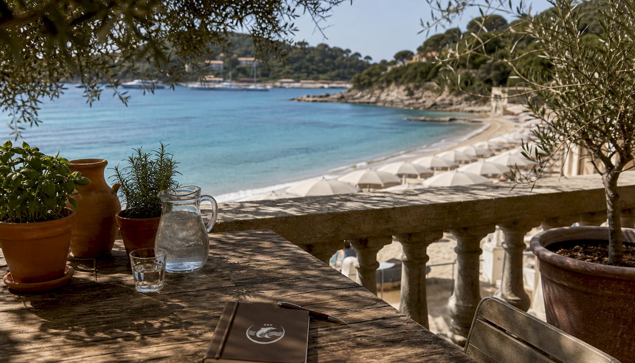 Splendida terrazza sul mare di un hotel all’Isola d’Elba, perfetta per godersi una vista mozzafiato sulla spiaggia.