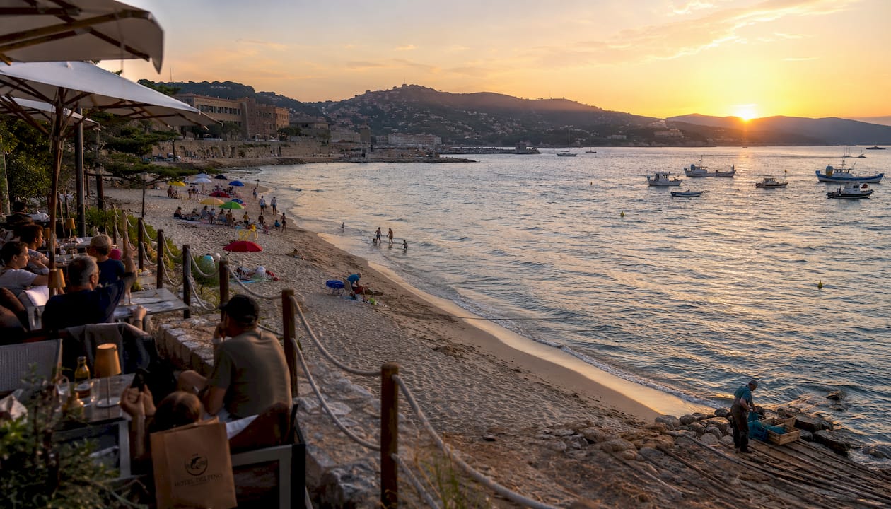 Il lungomare di Portoferraio baciato dal sole e la sua spiaggia invitano a una passeggiata rilassante tra colori vivaci e profumo di mare.